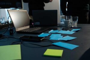 A laptop placed on a desk with various sticky notes, representing the planning process for technology spend compliance.